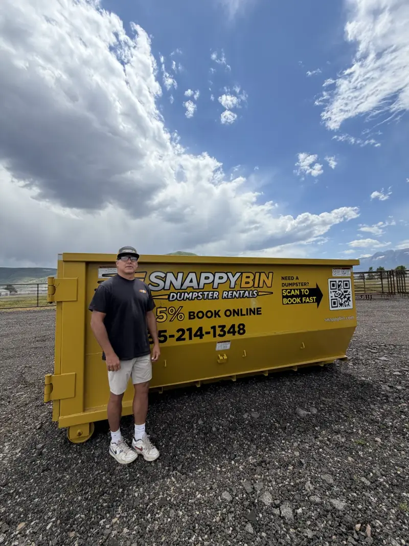 Snappy Bin owner Mike Vleck with a yellow roll-off dumpster in Park City, Utah