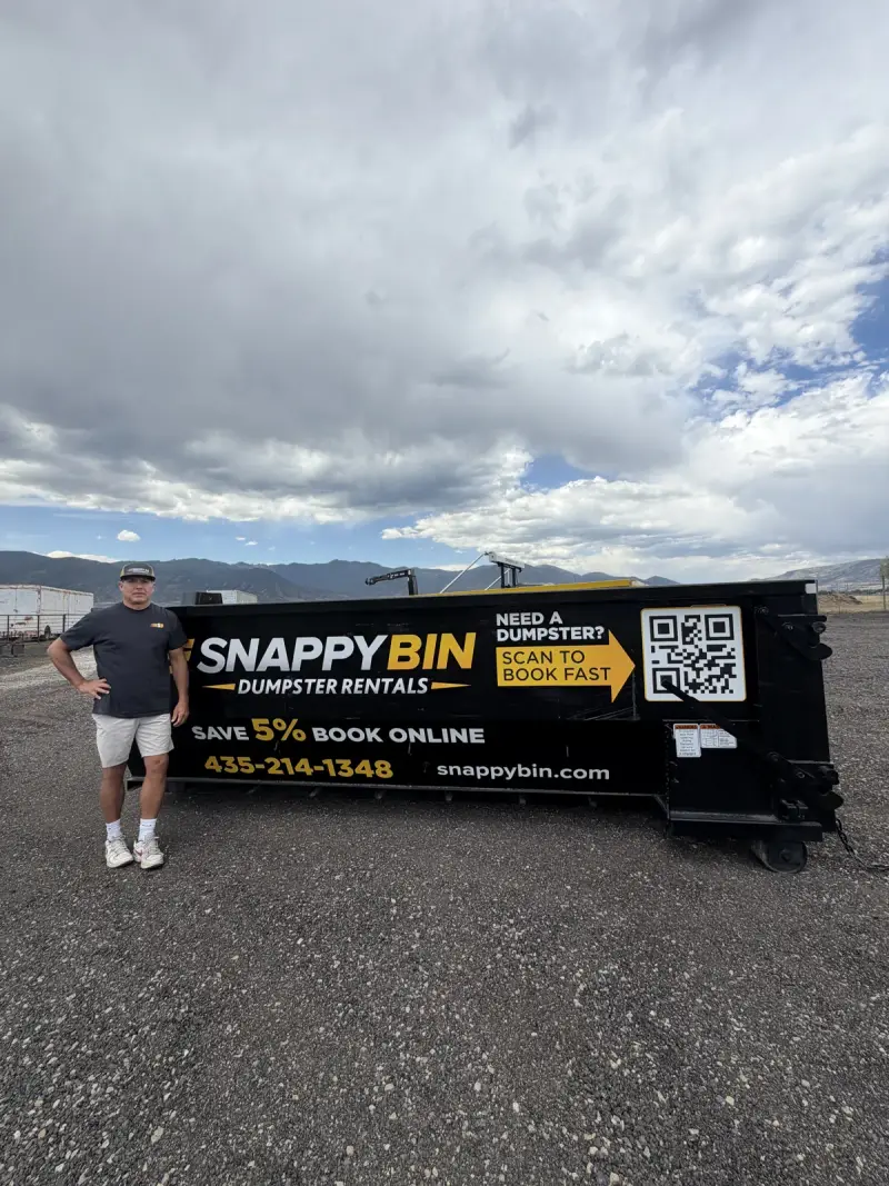 Snappy Bin roll-off dumpster staged for delivery under a stormy Wasatch Back sky